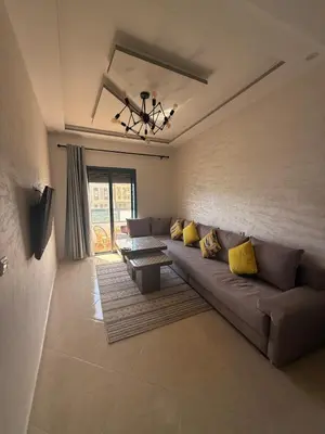 a living room with a couch and a table at Comfortable and quiet apartment with Buzzinga in Bouznika