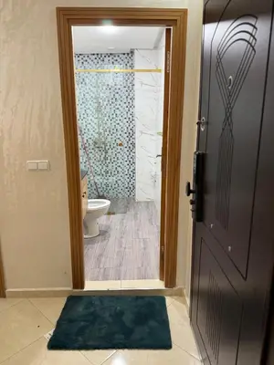 a bathroom with a toilet and a door leading to a shower at Comfortable and quiet apartment with Buzzinga in Bouznika