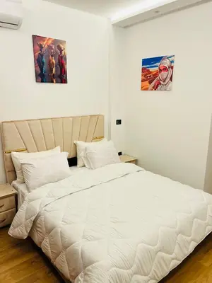 a bedroom with a large white bed with two pictures on the wall at Rafina in Casablanca
