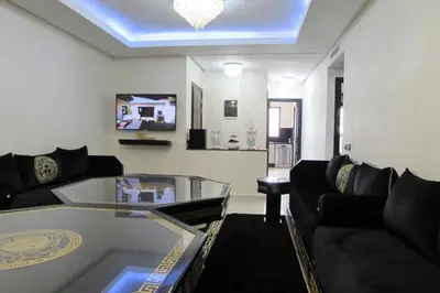 a living room with a couch and a glass table at APPARTEMENT luxe in Mansouria