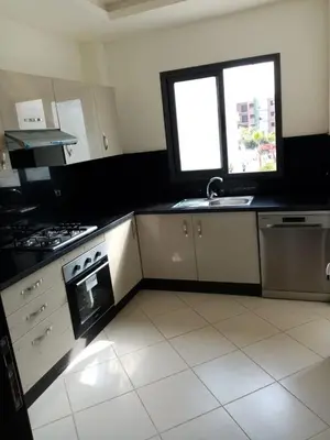 a kitchen with a stove and a sink and a window at APPARTEMENT luxe in Mansouria