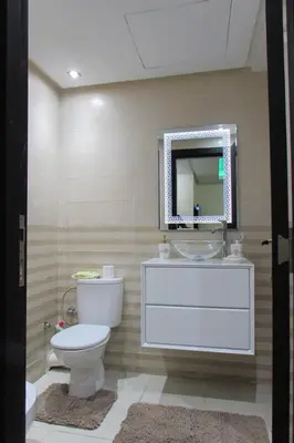 a bathroom with a toilet and a sink and a mirror at APPARTEMENT luxe in Mansouria