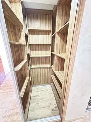 a walk in closet with wooden shelves at Comfortable, quiet and beach apartment in Skhirat