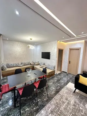 a room with a couch and a table and chairs at Apartment 1 CH près de la plage in Oulad Akkou