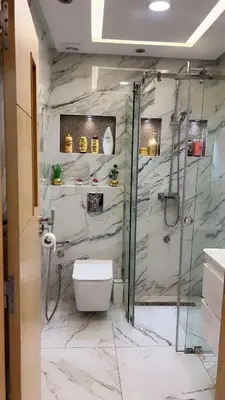 a bathroom with a toilet and a shower with marble walls at Charming apartment in Mansoria in Mohammedia