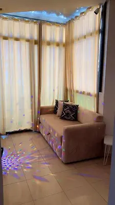a couch sitting in a room with lights at Charming apartment in Mansoria in Mohammedia