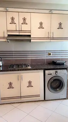 a kitchen with a stove and a washing machine at Charming apartment in Mansoria in Mohammedia