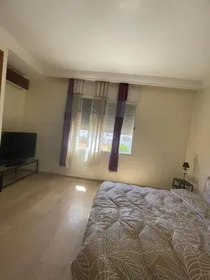 a bedroom with a bed and a television and a window at Villa à louer nouaceur 3 chambres in Nouaseur
