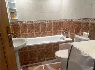 a bathroom with a toilet and a tub and a sink at Appartement à 2mn gare tgv Agdal in Rabat