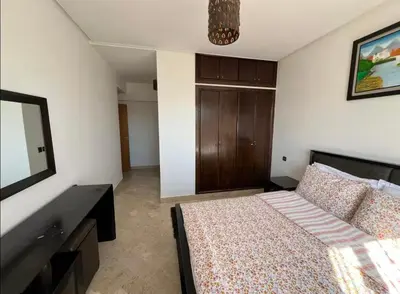 a bedroom with a bed with a dresser and a mirror at Appartement à 2mn gare tgv Agdal in Rabat