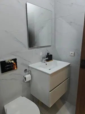 a bathroom with a sink and a toilet and a mirror at Casa Atlantica mit Meerblick und Poolparadies in Mansouria