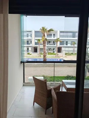 a room with a view of a building with a palm tree at Casa Atlantica mit Meerblick und Poolparadies in Mansouria