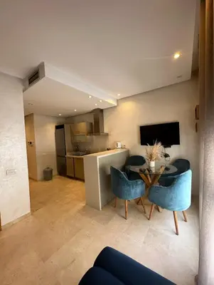 a living room with a table and chairs and a kitchen at Urban flat Bourgogne in Casablanca