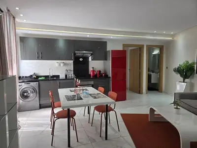 a kitchen and living room with a table and chairs at Tounarouz Studio in Casablanca