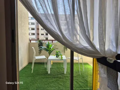 a balcony with a table and chairs and a window at aeroperla 11 aeroprt casa blanca in Nouaseur
