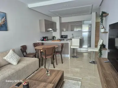 a living room and kitchen with a couch and a table at aeroperla 11 aeroprt casa blanca in Nouaseur