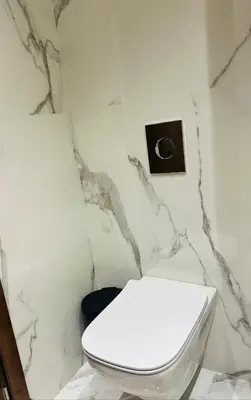 a bathroom with a white toilet and a clock on the wall at Studio Adam 18 CFC 2 minutes away in Casablanca