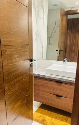 a bathroom with a sink and a wooden door at Studio Adam 18 CFC 2 minutes away in Casablanca