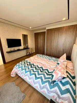 a bedroom with a bed and a tv on the wall at Studio Al Mahdi 23 CFC 2 minutes away in Casablanca