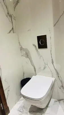 a bathroom with a white toilet and a clock on the wall at Studio Iza 08 CFC à 2mn in Casablanca
