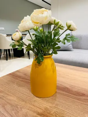 a yellow vase with white flowers sitting on a table at Studio le César 6 CFC 2 minutes away in Casablanca