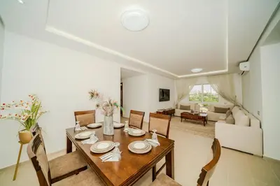 a dining room and living room with a table and chairs at Rabat Apartment in Rabat
