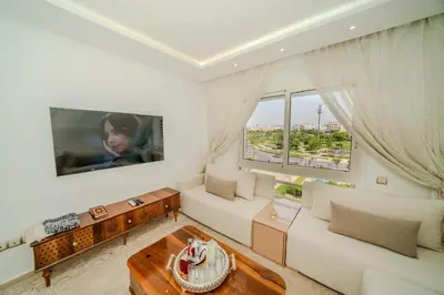 a living room with a white couch and a large window at Rabat Apartment in Rabat