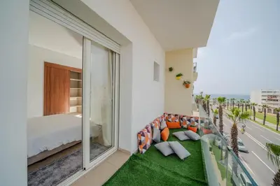 a room with a balcony with a bed and a couch at Rabat Apartment in Rabat