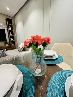 a table with plates and a vase of flowers on it at Studio New York 1 CFC 2 minutes away in Casablanca