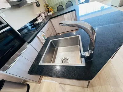 a kitchen sink with a faucet on a counter at Melrose Sea View, Pool & Garden in Tamaris