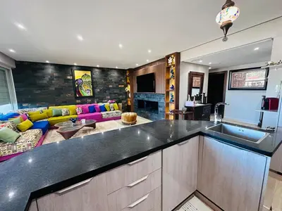 a kitchen with a counter top and a living room at Melrose Sea View, Pool & Garden in Tamaris