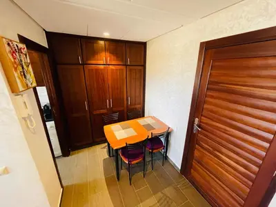 a kitchen with a table and chairs and a wooden door at Janat KLK, tamaris beach in Tamaris