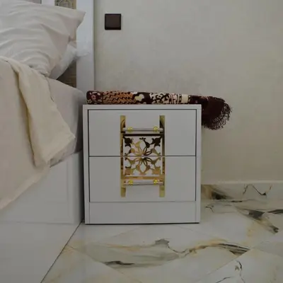 a white cabinet sitting on a floor next to a bed at tanger in Aïn Diab