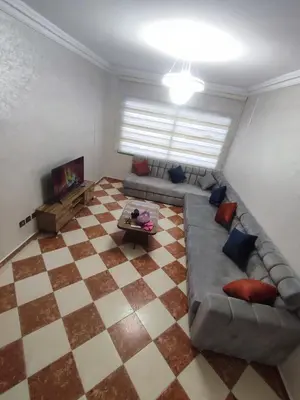 a living room with a couch and a checkered floor at tanger in Aïn Diab