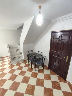 a room with a table and chairs and a staircase at tanger in Aïn Diab