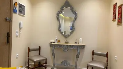 a mirror on a wall above a vanity with two chairs at Modern apartment in Skhirat 5 minutes from the beach in Skhirat