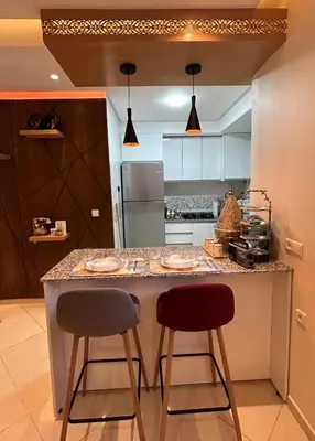 a kitchen with two stools at a kitchen counter at Modern apartment in Skhirat 5 minutes from the beach in Skhirat