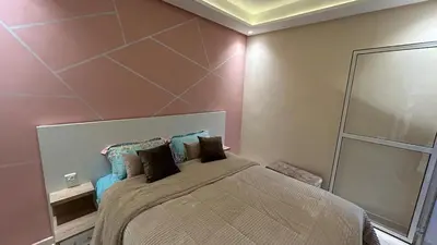 a bedroom with a bed and a mirror at Modern apartment in Skhirat 5 minutes from the beach in Skhirat