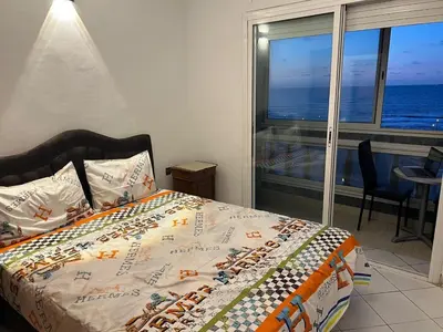 a bedroom with a bed with a view of the ocean at Spacious apartment beachfront city center in Casablanca