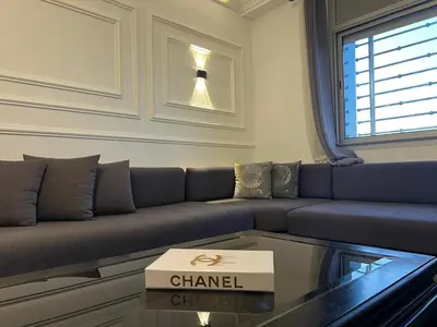 a living room with a couch and a glass table at Spacious apartment beachfront city center in Casablanca