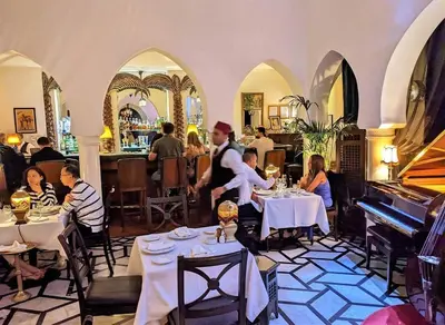 a group of people sitting at tables in a restaurant at Spacious apartment beachfront city center in Casablanca