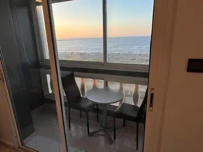 a table and chairs in a balcony with a view of the ocean at Spacious apartment beachfront city center in Casablanca