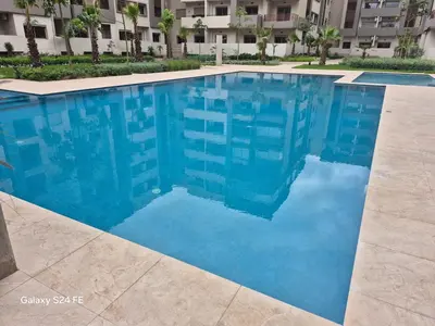 a blue swimming pool in front of a building at aeroperla 15 aéroport casa blanca in Nouaseur