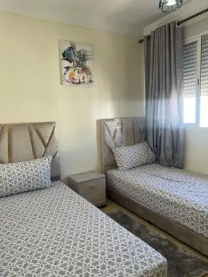 a bedroom with two beds and a window at Vue mer, confort, plage à 10 min in Sidi Rahal