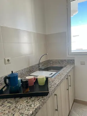 a kitchen counter with a sink and some cups at Vue mer, confort, plage à 10 min in Sidi Rahal