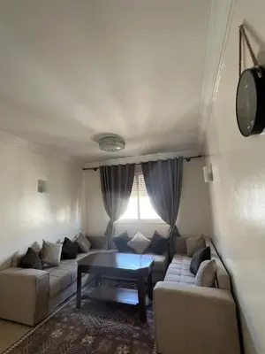 a living room with a couch and a table at Vue mer, confort, plage à 10 min in Sidi Rahal