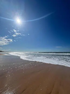 a beach with the ocean and the sun in the sky at Vue mer, confort, plage à 10 min in Sidi Rahal