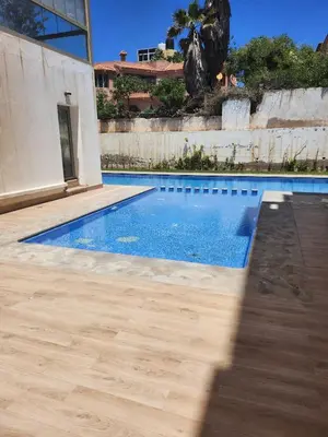 a swimming pool in a house with a wooden floor at Rita in Mohammedia