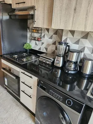 a kitchen with a stove and a washing machine at Rita in Mohammedia