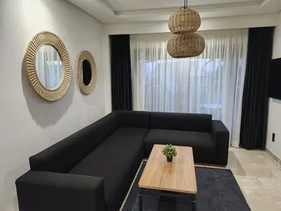 a living room with a black couch and a table at Rita in Mohammedia